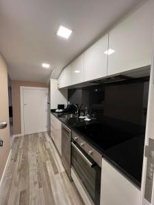 a kitchen with a black counter and a sink at Lux'Otel City Lodge in Barcelos