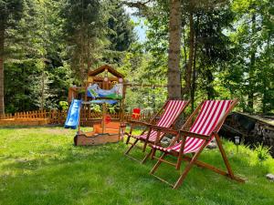 two lawn chairs and a playground in a yard at Apartmány 107 in Olešnice v Orlických horách
