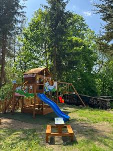 a playground with a slide and a play structure at Apartmány 107 in Olešnice v Orlických horách