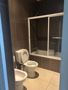 a bathroom with a toilet and a bath tub at Dee's 2 BR guest flat in Ladybrand in Ladybrand