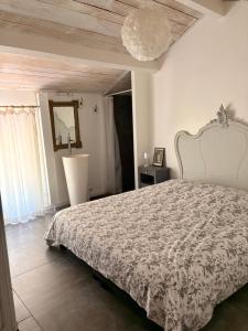 a bedroom with a large bed with a white bedspread at Mas des garrigues in Bouchet