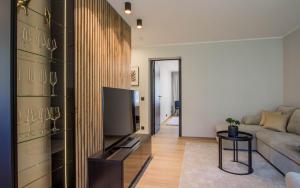 a living room with a couch and a tv at Uus Street Apartment, Modern Stay near City Centre with Free Parking in Tartu