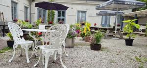 three chairs and a table with plants and an umbrella at Kalkbrottets Vandrarhem in Slite