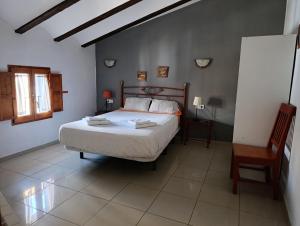 a bedroom with a bed and a table and a chair at Complejo Rural La Belluga in Segorbe