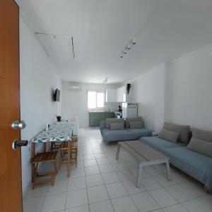 a living room with blue couches and a table at Olive Tree Villa in Nikiti
