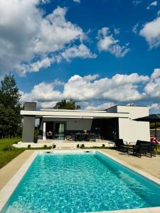 a house with a swimming pool in front of a house at Aurora Noir Retreat in Banja Luka