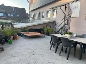 a patio with tables and chairs and a bench at Gemütliche Apartments in Bendorf