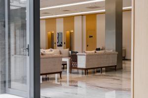 a lobby with chairs and a table in a building at Grand Afrosiyob Hotel in Tashkent
