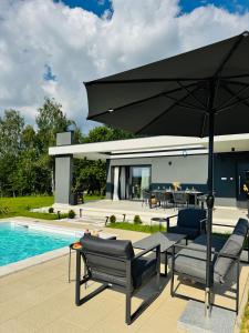 a patio with a black umbrella next to a pool at Aurora Noir Retreat in Banja Luka
