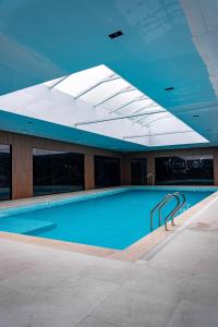 a large swimming pool with a skylight in a building at Grand Afrosiyob Hotel in Tashkent
