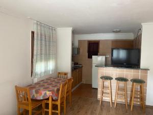 a kitchen with a table and chairs and a kitchen with a television at Emese Apartman in Hajdúszoboszló