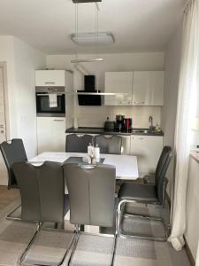 a kitchen with a white table and chairs at Apartman Orkic in Vodnjan