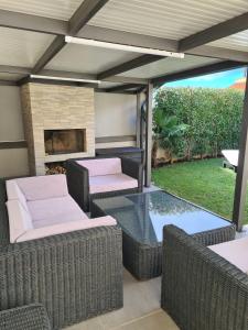 a patio with wicker chairs and a fireplace at Apartman Orkic in Vodnjan