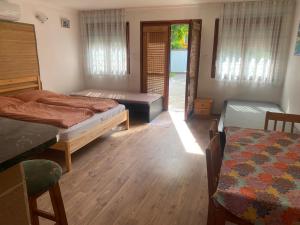 a room with two beds and a table and a bed sidx sidx sidx at Emese Apartman in Hajdúszoboszló