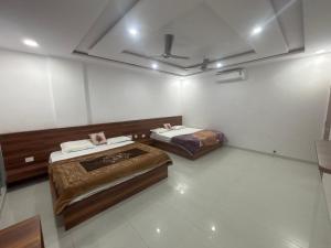 a room with two beds in a room at Lord Krishna hotel in Khātu
