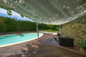 a swimming pool under a large umbrella at Mhateria Relais - Relax in Villa con Piscina in Toscana in Rignano sullʼArno
