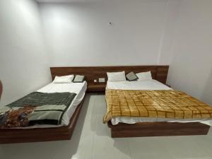 two beds sitting next to each other in a room at Lord Krishna hotel in Khātu +3 photos