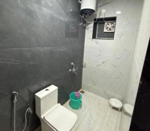 a bathroom with a white toilet and a black wall at Lord Krishna hotel in Khātu
