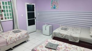 a room with two beds and a purple wall at House of Colors Hotel in Manaus