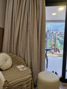 a bedroom with a bed and a large window at Pousada raios de sol in Chapada dos Guimarães