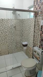 a bathroom with a toilet and a glass shower at House of Colors Hotel in Manaus +26 photos