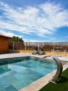a swimming pool with two chairs and a fence at La Ermita Casa Rural in Benablón