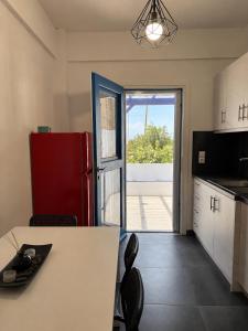 a kitchen with a white table and a red refrigerator at Serene Stay Kythnos in Flampouria +2 photos