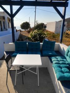 a couch with blue pillows and a table and chairs at Serene Stay Kythnos in Flampouria