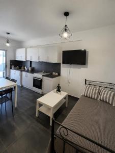 a living room with a couch and a table and a kitchen at Serene Stay Kythnos in Flampouria