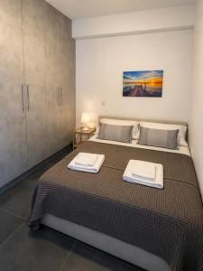 a bedroom with a bed with two towels on it at Serene Stay Kythnos in Flampouria