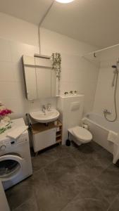 a bathroom with a sink and a toilet and a tub at 2 Zimmer Ferienwohnung nahe Schweiz in Bad Säckingen +19 photos