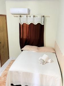 a white bed in a room with a window at Apartamento do Graf 2 in Sorriso