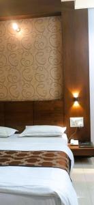 a bedroom with a bed and a wall with avertisement at New Hotel Shree Ganga in Shājāpur