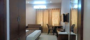 a small hotel room with a bed and a desk at New Hotel Shree Ganga in Shājāpur +16 photos