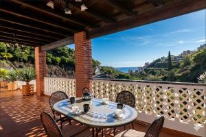 a table on a balcony with a view of the ocean at Villa Alabarce Nerja by Spain Sun Rentals in Nerja
