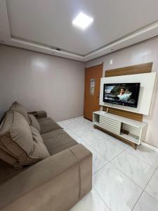 a living room with a couch and a flat screen tv at 01 Conforto e estilo-piscina e garagem inclusa in São Leopoldo