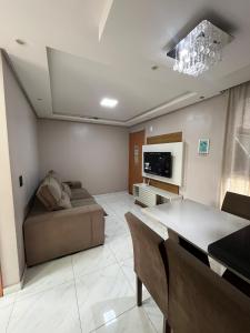a living room with a couch and a tv at 01 Conforto e estilo-piscina e garagem inclusa in São Leopoldo +28 photos