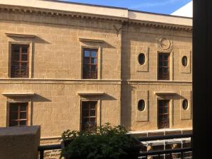 a brick building with windows and a clock on it at La Terrazza di Carolina in Agrigento