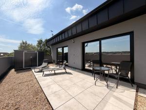 a patio with chairs and tables on a building at Apartmán Natalka7 in Bartovice +3 photos