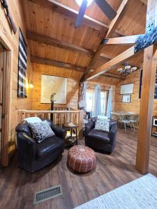 a living room with two chairs and a table at Cozy Forest Cabin with Hot Tub in Central Flagstaff in Flagstaff