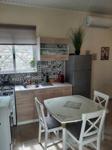 a kitchen with a table and chairs in a kitchen at Saint Giovanni House in Kharokopión