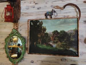 a painting hanging on a wall with a mirror at Etno House Šćepanov Hlad in Virpazar +44 photos