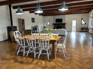 a dining room with a wooden table and chairs at Pokoje u Niny in Nowe Rumunki