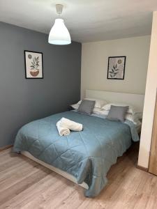 a bedroom with a bed with a blue comforter at Pokoje u Niny in Nowe Rumunki