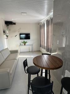 a living room with a table and a couch at University Suítes in Carmópolis