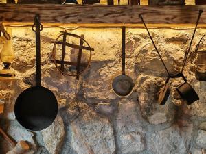 a group of utensils hanging on a stone wall at Etno House Šćepanov Hlad in Virpazar