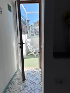 an open door to a patio with a rocking chair at Blumoon Capri con accesso Piscina in Anacapri