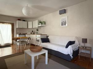 a living room with a couch and a kitchen at Le Châtaignier in Faveyrolles