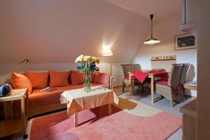 a living room with an orange couch and a table at Ferienhaus Mien Huske in Norderney