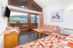 a living room with two couches and a balcony at Résidence Les Aiguilles de Warens - Combloux in Combloux